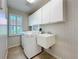 Well-lit laundry room featuring a washing machine, sink, and ample cabinet space at 5242 Highbury Cir, Sarasota, FL 34238