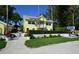 Charming yellow beach resort features a white picket fence and lush landscaping at 5581 Gulf Of Mexico Dr, Longboat Key, FL 34228