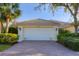 Two-car garage with brick paver driveway and well-maintained landscaping at 5618 Modena Pl, Sarasota, FL 34238