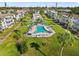 Beautiful aerial view of a community pool, tennis court, and surrounding condo buildings at 5907 Garden Ln # H26, Bradenton, FL 34207