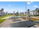 Community grilling area with picnic benches, shuffle board, and condo buildings at 5907 Garden Ln # H26, Bradenton, FL 34207