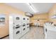 Bright laundry room with multiple washers and dryers, and folding area at 5907 Garden Ln # H26, Bradenton, FL 34207