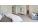 Modern bedroom with gray chaise lounge, bed, a large mirror, and white trim and walls at 6013 White Mangrove Ln, Bradenton, FL 34210