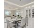 Elegant dining area boasts a modern chandelier, wine rack, and ample seating for memorable gatherings at 6013 White Mangrove Ln, Bradenton, FL 34210