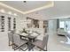 Open-concept dining and kitchen area with modern lighting, wine storage, and sleek gray cabinets at 6013 White Mangrove Ln, Bradenton, FL 34210
