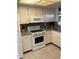 Well-lit kitchen with stainless steel appliances, tile flooring, and classic white cabinetry at 6032 Arlene Way, Bradenton, FL 34207