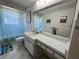 Functional bathroom featuring floral wallpaper, an extended vanity, and a tub at 604 Dundee Ln, Holmes Beach, FL 34217