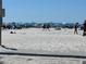 Wide sandy beach with clear blue water and people enjoying a sunny day at 604 Dundee Ln, Holmes Beach, FL 34217