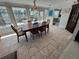 Bright dining area with a wooden table set for six, large windows, and views of the backyard pool area at 604 Dundee Ln, Holmes Beach, FL 34217