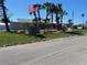 Charming community building with manicured lawn, palm trees and flag at 604 Dundee Ln, Holmes Beach, FL 34217