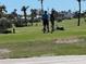 Golf course view, with manicured greens and golfers on the tee at 604 Dundee Ln, Holmes Beach, FL 34217