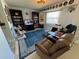 Relaxing living room with a plush blue rug, dark wood shelving, and a comfortable recliner for lounging at 604 Dundee Ln, Holmes Beach, FL 34217