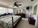 Comfortable main bedroom features a wooden bed frame, ceiling fan, and traditional dressers for a relaxing retreat at 604 Dundee Ln, Holmes Beach, FL 34217