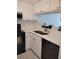 Modern kitchen with white cabinets, black appliances, and light countertops at 6924 Stones Throw N Cir # 8105, St Petersburg, FL 33710