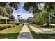 Outdoor shuffleboard court viewed from sidewalk framed by lush green grass and a small hedge at 7193 W Country Club N Dr # 140, Sarasota, FL 34243