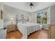 Cozy main bedroom boasts a large window overlooking a treed green space and hardwood floors at 7416 Botanica Pkwy # 103, Sarasota, FL 34238