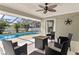 Relaxing screened lanai with a ceiling fan and patio furniture overlooking the pool at 7520 Curtiss Ave, Sarasota, FL 34231