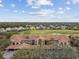 Aerial view of a community with tiled-roof homes, lush greenery, and a golf course at 803 Fairwaycove Ln # 106, Bradenton, FL 34212