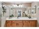 Bathroom featuring a vanity with wooden cabinets, a wide mirror, and a view to the bedroom at 803 Fairwaycove Ln # 106, Bradenton, FL 34212