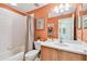 Cozy bathroom featuring a shower-tub combination, patterned walls, and neutral-toned vanity at 803 Fairwaycove Ln # 106, Bradenton, FL 34212