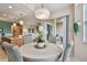 Dining area with round table, woven chairs, modern chandelier and view to the kitchen and lanai at 803 Fairwaycove Ln # 106, Bradenton, FL 34212