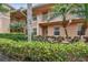Charming condo building featuring well-kept landscaping, balconies, and tropical palm trees at 803 Fairwaycove Ln # 106, Bradenton, FL 34212