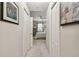 Hallway view to bedroom with ceiling fan and window. Artwork flanks each side, doors line the hall at 803 Fairwaycove Ln # 106, Bradenton, FL 34212