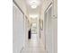 Well-lit hallway features white tile floors, ample closet space, and a stylish console table with a decorative mirror at 803 Fairwaycove Ln # 106, Bradenton, FL 34212