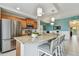 Open kitchen with stainless steel appliances, granite counters, and island seating overlooking the living area at 803 Fairwaycove Ln # 106, Bradenton, FL 34212