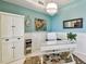 Charming home office featuring light blue walls with white wainscoting, glass desk, and decorative chandelier at 803 Fairwaycove Ln # 106, Bradenton, FL 34212