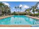 Beautiful community pool reflecting palm trees, providing a relaxing oasis and enhancing the community's appeal at 803 Fairwaycove Ln # 106, Bradenton, FL 34212
