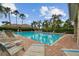 Community pool featuring a brick deck surrounded by palm trees and comfortable lounge seating at 803 Fairwaycove Ln # 106, Bradenton, FL 34212