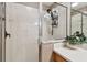 Tiled shower stall with a glass door, complemented by a vanity with a light countertop and decorative plants at 803 Fairwaycove Ln # 106, Bradenton, FL 34212