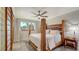 Cozy bedroom featuring a unique wooden bed frame, ceiling fan, and ample natural light at 101 Base E Ave # 101 103, Venice, FL 34285