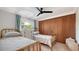 Bright bedroom with two twin beds, a black ceiling fan, and a spacious closet with sleek wood panel doors at 101 Base E Ave # 101 103, Venice, FL 34285