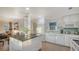 Modern kitchen with white cabinetry, a sleek island, and stainless steel appliances offering a functional cooking space at 101 Base E Ave # 101 103, Venice, FL 34285
