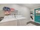 Efficient laundry room featuring modern machines and storage for household essentials at 101 Base E Ave # 101 103, Venice, FL 34285