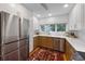 Contemporary kitchen with stainless steel refrigerator, updated white cabinetry, and a colorful oriental rug at 101 Tern Dr, Anna Maria, FL 34216