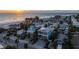 Scenic aerial view of a coastal neighborhood with colorful homes near the beach during sunset at 108 Magnolia Ave, Anna Maria, FL 34216