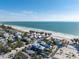 Beautiful aerial view of a coastal home near the beach, surrounded by lush greenery and other homes at 108 Magnolia Ave, Anna Maria, FL 34216