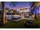 Backyard with a luxurious pool, hot tub, outdoor seating, fire pit, and lush greenery at 108 Magnolia Ave, Anna Maria, FL 34216