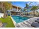 Inviting backyard featuring a swimming pool, spa, covered patio, and lush landscaping for outdoor enjoyment at 108 Magnolia Ave, Anna Maria, FL 34216