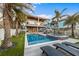 An inviting backyard boasts a stunning pool, relaxing lounge chairs, and tropical palm trees at 108 Magnolia Ave, Anna Maria, FL 34216