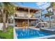Beautiful backyard showcasing a sparkling pool, outdoor seating, and lush palm trees at 108 Magnolia Ave, Anna Maria, FL 34216