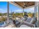 Relaxing outdoor balcony featuring comfortable seating, a grill, and beautiful views of lush tropical landscaping at 108 Magnolia Ave, Anna Maria, FL 34216