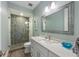 Modern bathroom with a glass-enclosed shower, decorative tile, and sleek vanity with stylish fixtures at 108 Magnolia Ave, Anna Maria, FL 34216