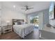 Bright bedroom with a white bed and a view of the palm trees outside at 108 Magnolia Ave, Anna Maria, FL 34216