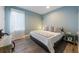 Serene bedroom with soft blue walls, comfortable queen bed, and natural light from a large window at 108 Magnolia Ave, Anna Maria, FL 34216