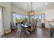 Elegant dining area with a large wooden table, stylish chairs, and bright natural light from large windows at 108 Magnolia Ave, Anna Maria, FL 34216
