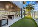 Outdoor kitchen area with bar seating and mini-golf adjacent to the covered outdoor lounge at 108 Magnolia Ave, Anna Maria, FL 34216